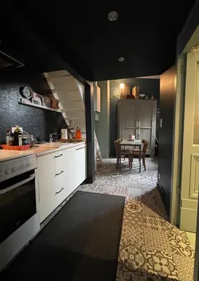 a kitchen with white cabinets and a table in a room at Studio Dageraad in Antwerp