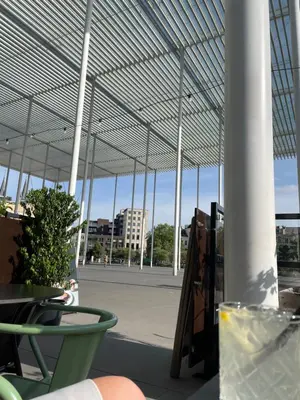 a large pavilion with a table and chairs and a building at Antwerpcityhome in Antwerp