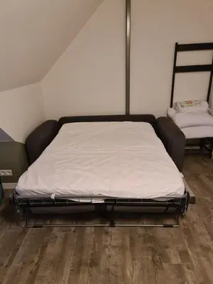 a large bed in a room with a wooden floor at De Gorzen in Oud-Turnhout