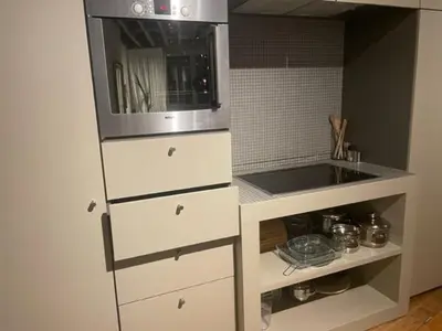 a kitchen with white cabinets and a microwave at Duplex dernier étage avec terasse à deux pas de la grand place in Brussels