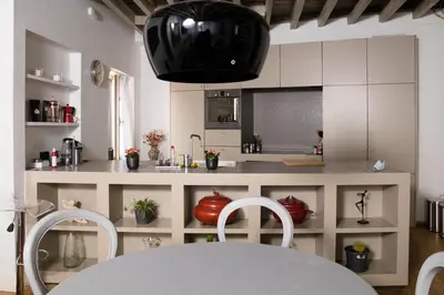 a kitchen with white cabinets and a table and chairs at Duplex dernier étage avec terasse à deux pas de la grand place in Brussels
