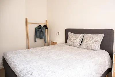 a bedroom with a bed and a jacket hanging on the wall at Quiet and cosy apartment near the city center of Diest in Diest
