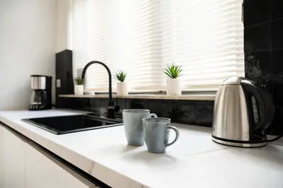 two mugs sitting on a kitchen counter next to a sink at Quiet and cosy apartment near the city center of Diest in Diest
