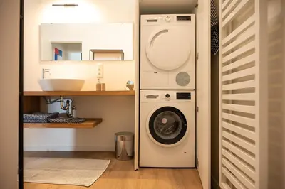 a bathroom with a washing machine and a sink at Quiet and cosy apartment near the city center of Diest in Diest