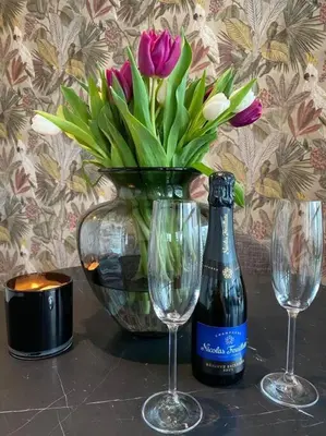 a bottle of wine and two glasses and a vase with flowers at 