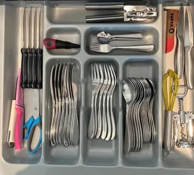 a plastic container filled with forks and spoons and utensils at 