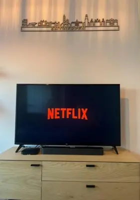 a television on a dresser with a netflix sign on it at 