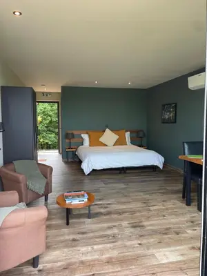 a bedroom with a bed and a couch and a table at Hallerbos B&B in Bluebell Forest in Halle