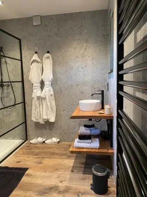 a bathroom with white robes hanging on a wall at Hallerbos B&B in Bluebell Forest in Halle