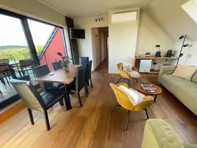a living room with a table and a couch at Hallerbos B&B in Bluebell Forest in Halle
