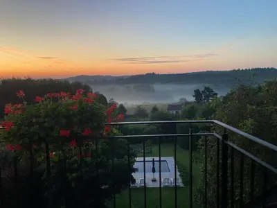 a view from the balcony of a house with fog in the distance at Hallerbos B&B in Bluebell Forest in Halle
