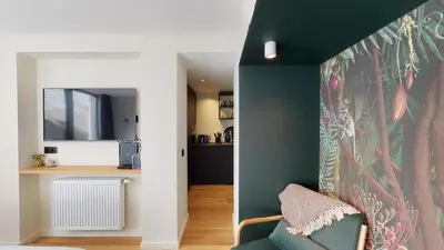 a living room with a green wall and a couch at Suite lumineuse à Saint-Gilles in Brussels