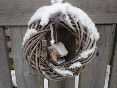 a wreath on a wooden fence with snow on it at Natuurschoon Vakantiewoning Moorsel in Moorsel
