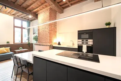 a kitchen with a large island in a room at The Hendrik Square Residence in Antwerp