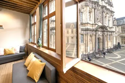 a room with a view of a city from a window at The Hendrik Square Residence in Antwerp
