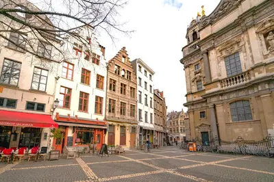 a city street with buildings and tables and chairs at The Hendrik Square Residence in Antwerp