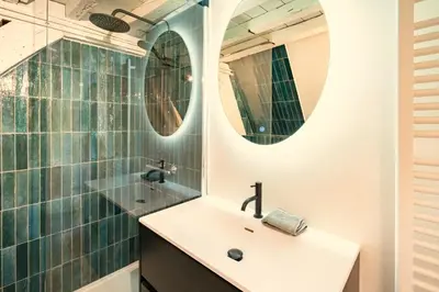 a bathroom with a sink and two mirrors at The Hendrik Square Residence in Antwerp