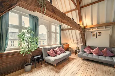 a living room with two couches and two windows at The Hendrik Square Residence in Antwerp
