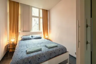 a bedroom with a bed with two pillows on it at The Charming Hendrik Square Apartments in Antwerp