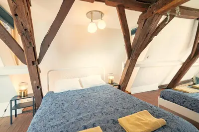 a bedroom with two beds in a room with wooden beams at The Charming Hendrik Square Apartments in Antwerp