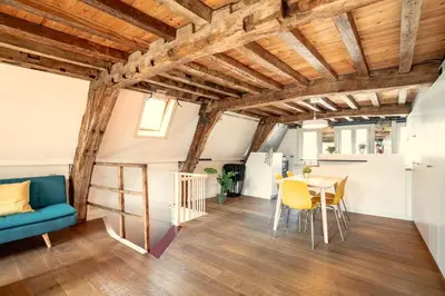 a living room with wooden ceilings and a table and chairs at The Charming Hendrik Square Apartments in Antwerp