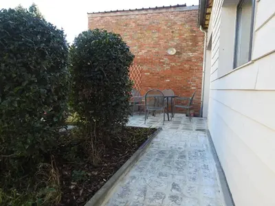 a patio with a table and chairs next to a building at Herselt Garden Shed Retreat in Herselt