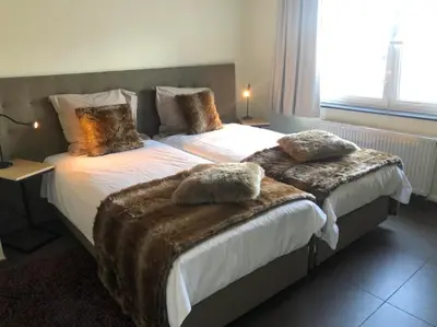 a bedroom with two twin beds with blankets on them at Logies Dampoort in Ghent