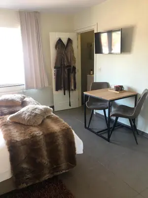 a bedroom with a bed and a table and a table and chairs at Logies Dampoort in Ghent