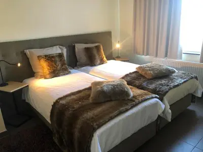 a hotel room with two beds with furry blankets at Logies Dampoort in Ghent