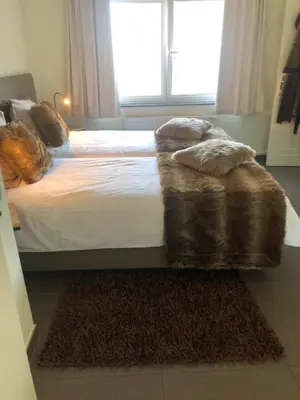a bedroom with a bed and a large window at Logies Dampoort in Ghent