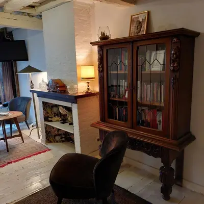 a living room with a large wooden cabinet and a chair at Plezantwerpen, Zuiderzin in Antwerp