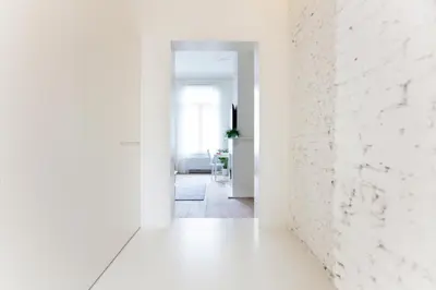 an empty hallway with white walls and a white brick wall at Maison Nationale City Flats & Suites in Antwerp