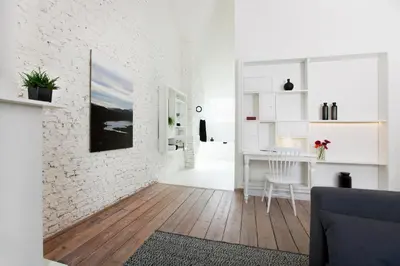 a white living room with a white brick wall at Maison Nationale City Flats & Suites in Antwerp