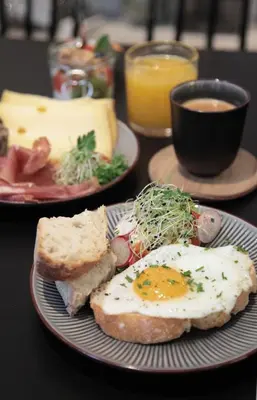 a plate with an egg and bread and a cup of coffee at Maison Nationale City Flats & Suites in Antwerp