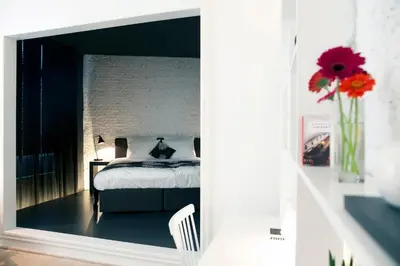 a bedroom with a bed and a vase of flowers at Maison Nationale City Flats & Suites in Antwerp