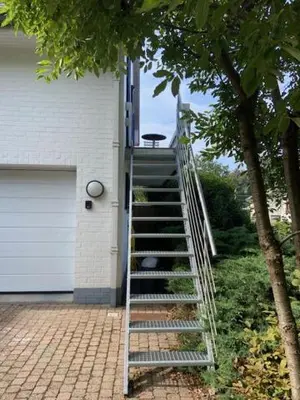 a ladder leading up to a house with a garage at narcisses in Sint-Genesius-Rode