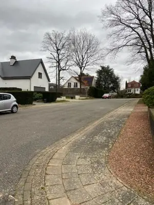 a street with a car parked on the side of the road at narcisses in Sint-Genesius-Rode