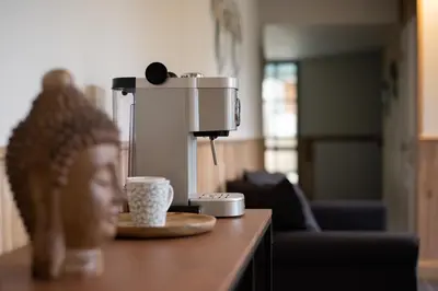 a coffee machine sitting on a table in a living room at Domein Den Buiten Bed And Breakfast DnD in Sint-Niklaas