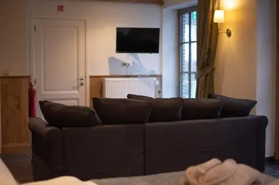 a living room with a couch and a television at Domein Den Buiten Bed And Breakfast DnD in Sint-Niklaas
