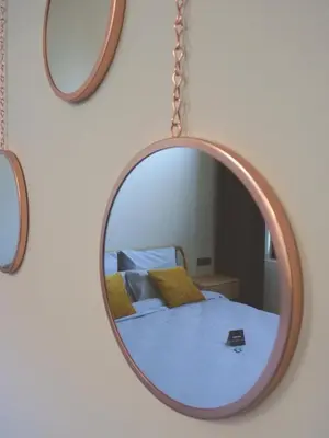 a mirror hanging on a wall next to a bed at Site78 in Puurs