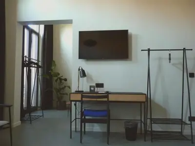 a room with a desk and a television on a wall at Site78 in Puurs