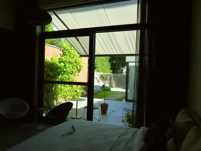 a bedroom with a bed and a large window at Site78 in Puurs