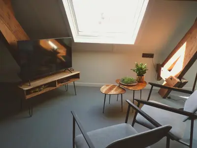 a living room with a flat screen tv and chairs at Site78 in Puurs