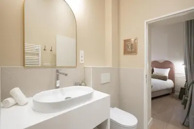 a white bathroom with a sink and a mirror at SHWAY - Le Lambermont in Antwerp