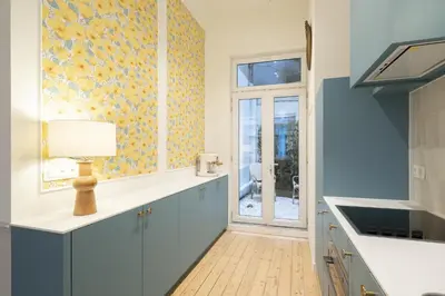 a kitchen with blue cabinets and a window at SHWAY - Le Lambermont in Antwerp