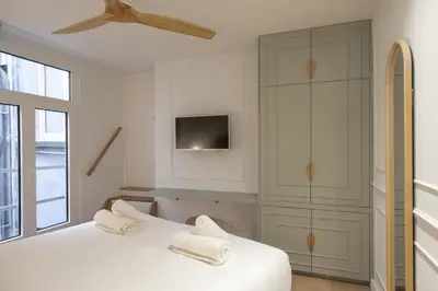 a bedroom with two white beds and a tv at SHWAY - Le Leopold in Antwerp