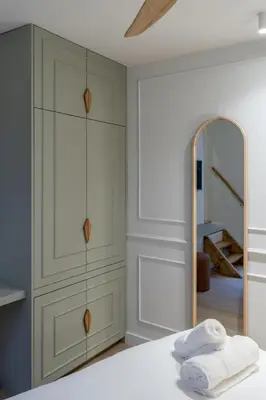a bedroom with white cabinets and a mirror at SHWAY - Le Leopold in Antwerp