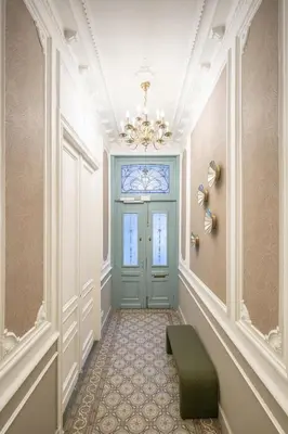a hallway with a blue door and a green ottoman at SHWAY - Le Marnix in Antwerp
