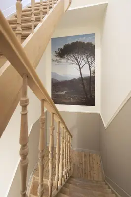 a staircase with a painting of a tree on the wall at SHWAY - Le Marnix in Antwerp