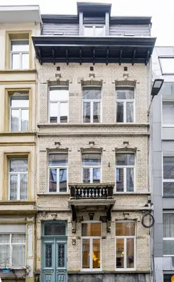 a large brick building with windows and a balcony at SHWAY - Le Marnix in Antwerp